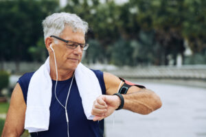 Ældre mand tjekker sit ur efter en veloverstået træning uden slid på kroppen pga. lav belastning
